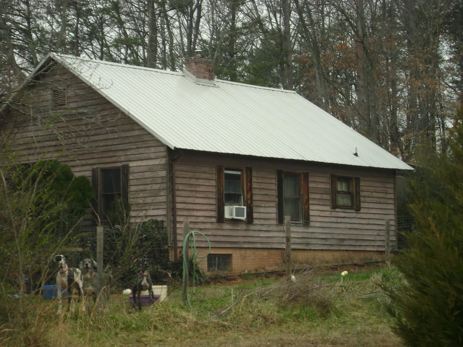 White metal roof on an old wood sided farmhouse, from a Metal Roof Installation job in Gilby