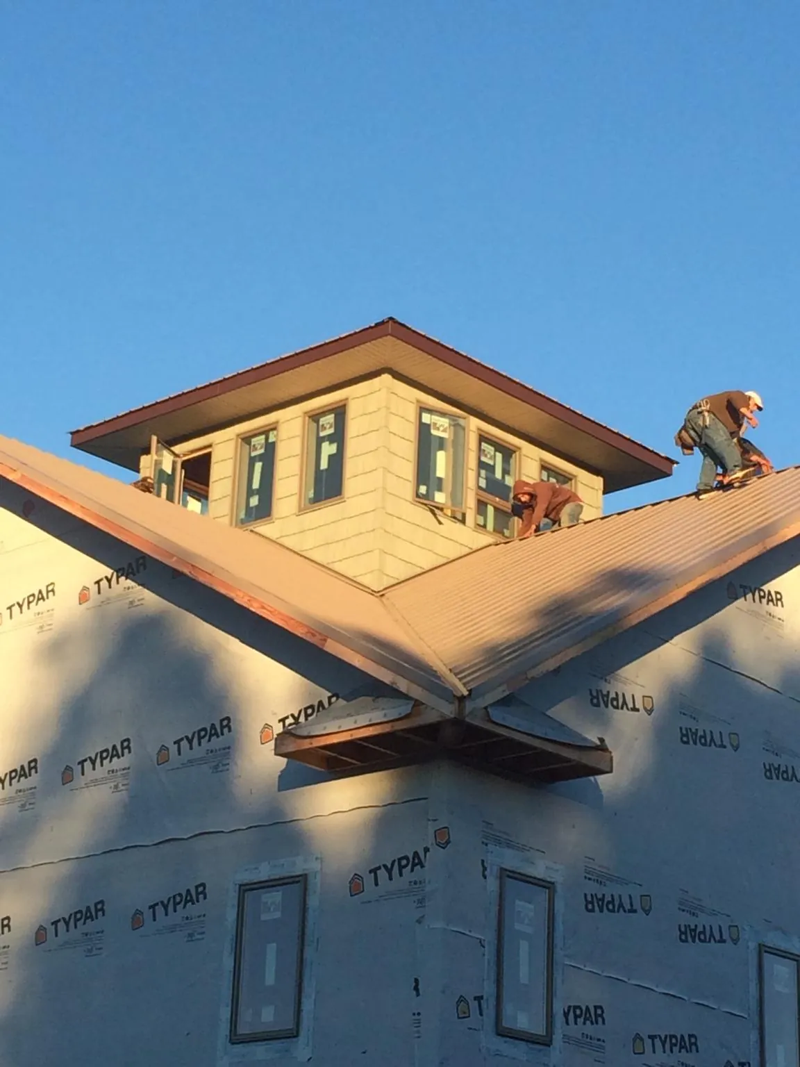 Roofers working around a rooftop cupola on a new metal roof at sunset — Roof Waterproofing in Gilby by Roofing Brothers